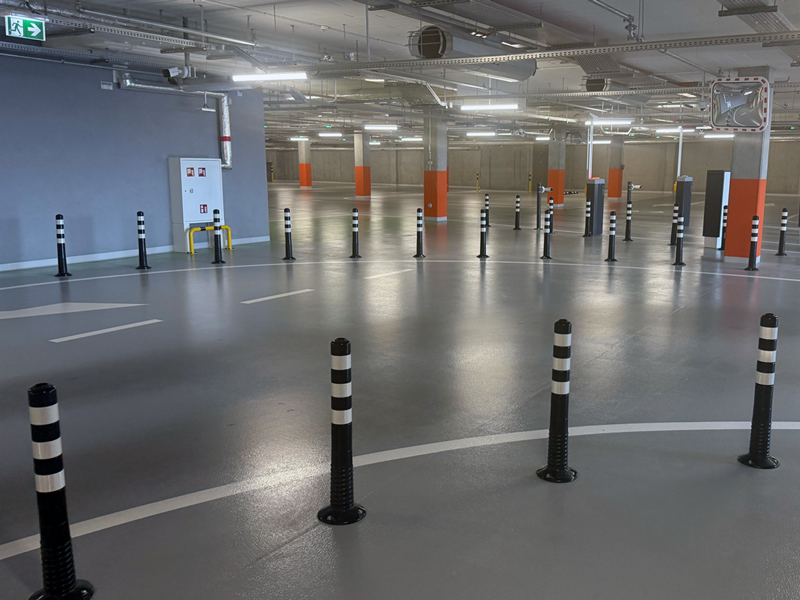 Słupki elastyczne wyznaczające pas ruchu na parkingu podziemnym