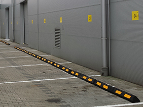 Gumowe separatory parkingowe chroniące elewację hali produkcyjnej